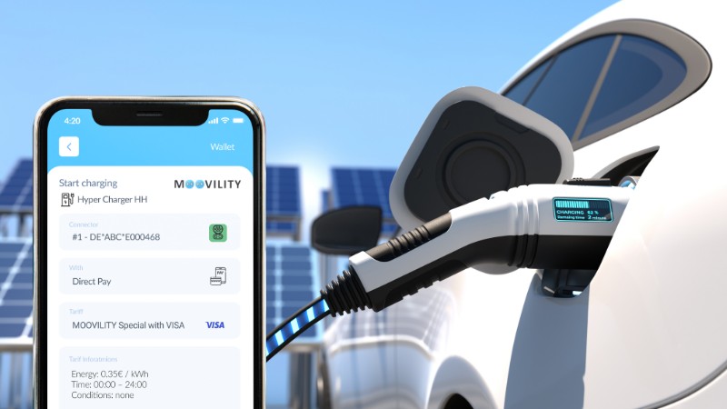 moovility app on phone next to electric car being charged
