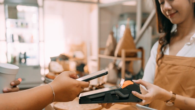 women taking a payment using a phone